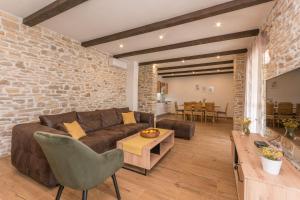 a living room with a couch and a brick wall at Villa Vitis ZadarVillas in Oklaj