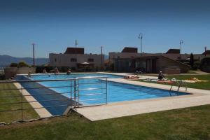 une grande piscine avec des personnes assises autour de celle-ci dans l'établissement Apartamento Familiar con vistas *****, à Baiona