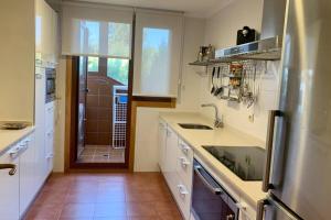 une cuisine avec un évier et un plan de travail dans l'établissement Apartamento Familiar con vistas *****, à Baiona