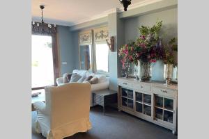 un salon avec un canapé et une table avec des fleurs dans l'établissement Apartamento Familiar con vistas *****, à Baiona 32 autres photos