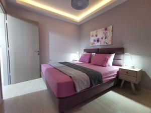um quarto com uma cama grande e lençóis cor-de-rosa em Mon Repo Nest em Corfu Town