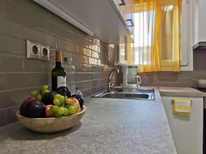 uma taça de fruta no balcão da cozinha com uma garrafa de vinho em Mon Repo Nest em Corfu Town