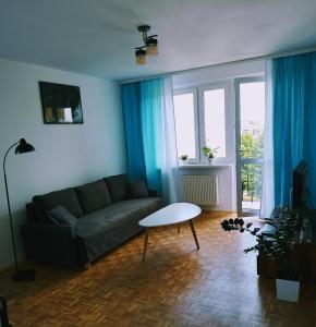 een woonkamer met een bank en een tafel bij Mieszkanie Turkus w Gnieźnie in Gniezno