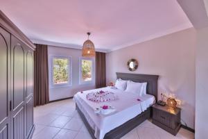 a bedroom with a large white bed with flowers on it at Hill House Adult Only in Kaş