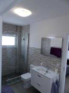 a bathroom with a toilet and a sink and a shower at Lanzarotearena in Tinajo +12 photos