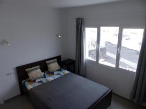 um quarto com uma cama e uma grande janela em Lanzarotearena em Tinajo