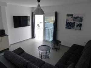 uma sala de estar com um sofá e duas mesas em Lanzarotearena em Tinajo
