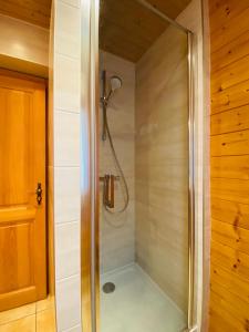 una doccia con porta in vetro in bagno di Chalet Myrtille a Gérardmer