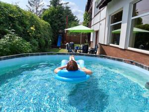 a woman is sitting on a raft in a swimming pool at Apartament Reda z prywatną sauną in Reda