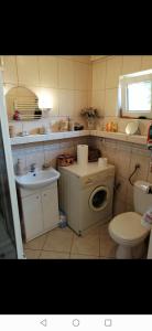 La salle de bains est pourvue de toilettes, d'un lavabo et d'un lave-linge. dans l'établissement Pokój u Lucyny, à Gdańsk