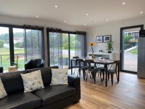 a living room with a black couch and a table at Chalet Manhattan in Gérardmer