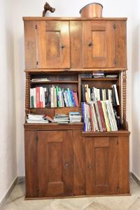 a wooden book shelf with books on it at Chez Paulette - meublé de tourisme classé 3 étoiles in Zonza