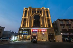 a large building with a clock tower on a street at Sun Park Hotel Suites in Jeddah