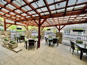 a patio with tables and chairs under a wooden pergola at Pension Silvie in Vlašim