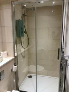 een douche met een glazen deur in de badkamer bij Ideally located 2 bedroom luxury apartment in Bath