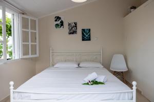 Una cama blanca con dos toallas blancas. en Sea View Residence en Nea Kios