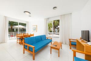 ein Wohnzimmer mit einem blauen Sofa und einem Tisch in der Unterkunft Apartamento Via Alemanya in Can Picafort