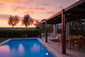 un patio trasero con piscina y terraza de madera en Aeriko Homes of Distinction, en Lefkada