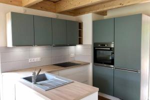 a kitchen with green cabinets and a sink in it at NOUVEAU: La cabine du bout du monde - Les Pierres Noires - votre résidence finistérienne de haut standing (GL2) in Crozon