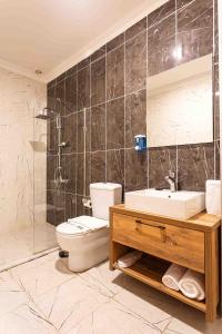 bagno con servizi igienici, lavandino e specchio di Marina Park Hotel a Istanbul
