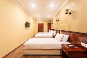 a hotel room with three beds and a tv at Marina Park Hotel in Istanbul