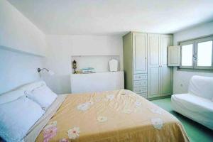 a bedroom with a bed and a couch in it at Naousa Home with full sea views in Naousa