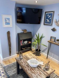 a living room with a table and a tv on the wall at Tiny Beach House in Saint Annes on the Sea