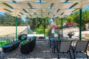 a patio with a table and chairs under a pergola at Thanos Cottage in Vlachopoulátika