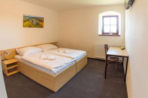 - une chambre avec un lit, une table et une chaise dans l'établissement Hospoda na sýpce, à Kuks