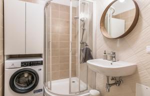 a bathroom with a sink and a washing machine at Cozy Modern Studio - Great for Short Trips in Riga