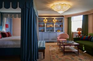 a bedroom with a bed and a living room at The Mitre, Hampton Court in Kingston upon Thames