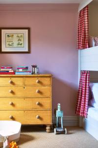 a bedroom with a dresser and a bunk bed at The Mitre, Hampton Court in Kingston upon Thames