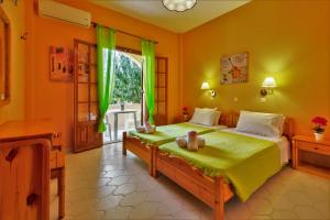 a bedroom with a bed with green curtains and a window at Villa Olive apartments in Ipsos