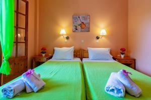 dwa łóżka w pokoju z zieloną pościelą w obiekcie Villa Olive apartments w mieście Ýpsos