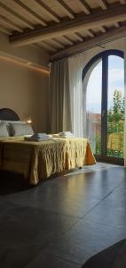 a bedroom with a bed and a large window at Vistaperdue in Peccioli
