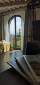a room with a bed and a large window at Vistaperdue in Peccioli