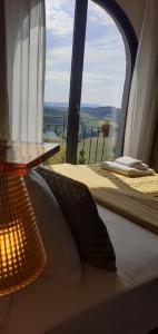 a bedroom with a bed and a window with a view at Vistaperdue in Peccioli