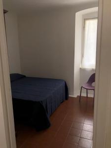 una camera con un letto e una sedia e una finestra di alice & cecy's little apartment a Lerici