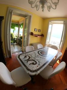 une salle à manger avec une table et des chaises blanches dans l'établissement Villa Reginella, à Varenna