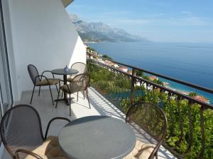 balcone con tavoli, sedie e vista sull'oceano di Apartment NoStress a Pisak