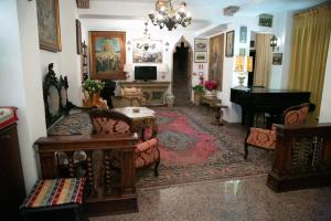 a living room filled with furniture and a piano at Hotel La Riva in Giardini Naxos