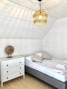 a bedroom with a bed and a chandelier at Playa Pobierowo in Pobierowo