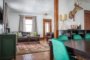 a living room with a table and green chairs at The Blue House on Front Downtown Traverse City in Traverse City
