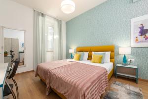 a bedroom with a large bed with yellow pillows at Polesana Rooms in Pula