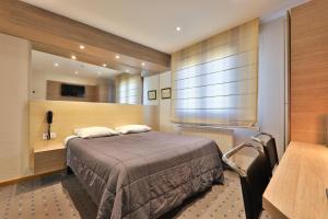 1 dormitorio con cama, mesa y ventana en Hôtel Restaurant et Spa Au Tilleul, en Labaroche