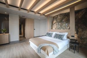 a bedroom with a large bed and a stone wall at panorama new generation in Sfakia