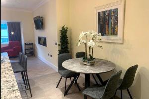 a dining room with a table with chairs and a vase of flowers at Apartment, Kilkenny City in Kilkenny