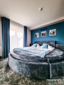 a bedroom with a large bed with a large ottoman at Hotel Moran & SPA in Powidz