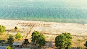 - une vue sur la plage avec des arbres et l'eau dans l'établissement Mareleon Camping, à Ofrynio