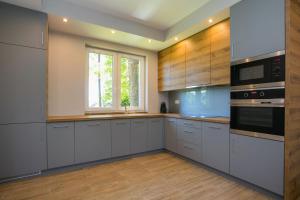 a kitchen with white cabinets and a window at Grabina Mazury in Stare Juchy